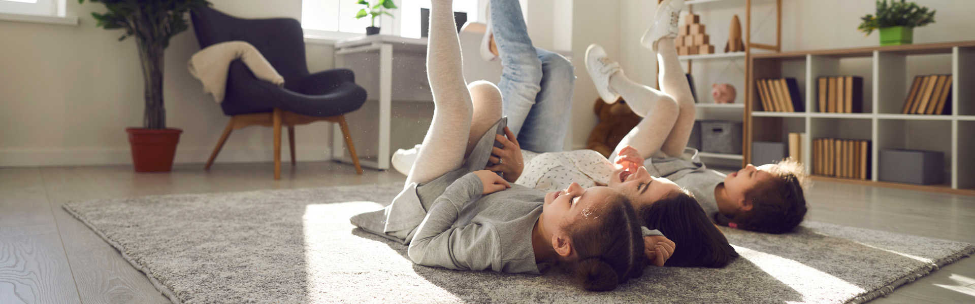 kinderen die liggen op de grond en spelen in een warme ruimte door de warmtepomp buitenunit van Sinclair genaamd Monoblock